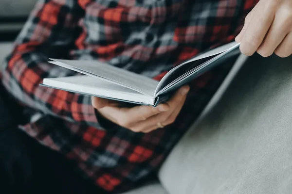 Hipster homem em vermelho xadrez livro de leitura camisa e mentiras sobre o — Fotografia de Stock