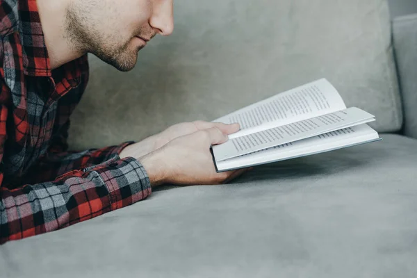 Hipster homem em vermelho xadrez livro de leitura camisa e mentiras sobre o — Fotografia de Stock