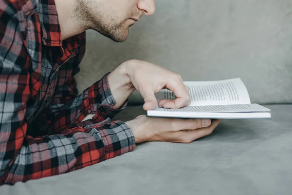 Hipster yakışıklı kırmızı Kareli gömlekli yalan ve kitap okuma — Stok fotoğraf