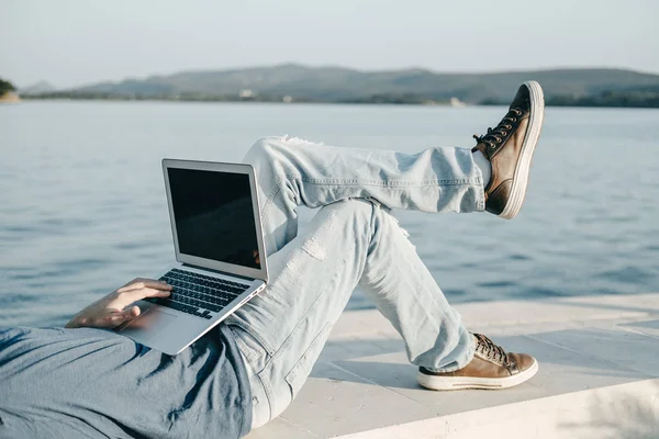 N을 앉아 노트북으로 작업 하는 젊은 남자 프리랜서의 자르기 사진 — 스톡 사진