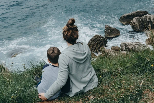 Hipster moeder en haar zoon kijken dat een crashen golven op zee, Mon — Stockfoto