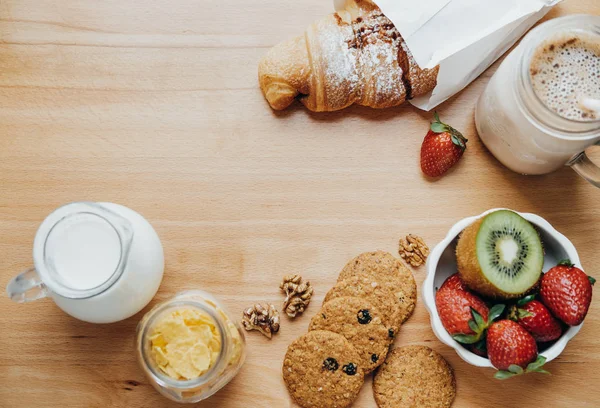 Söt frukost: croissant, jordgubbar, kiwi, flingor, mjölk och c — Stockfoto