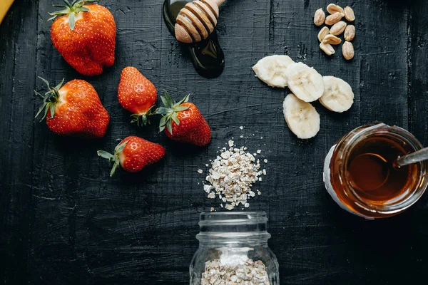 Ingredienser till frukost: havregryn, jordgubbar, honung, bananer o — Stockfoto