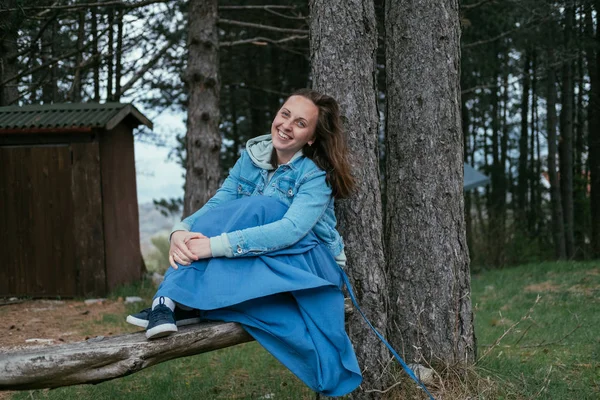 Mladá šťastná žena s úsměvem sedí venku. Vítr ve vlasech — Stock fotografie