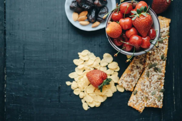 Healthy breakfast: corn flakes, strawberries, cherries, dates, a