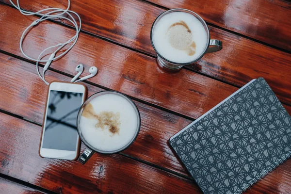 Smartphone, bärbar dator, hörlurar, kopp kaffe på bordet, topp vi — Stockfoto