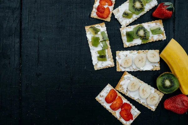 Crackers with cheese and fruits: bananas, strawberries and kiwi — Stock Photo, Image