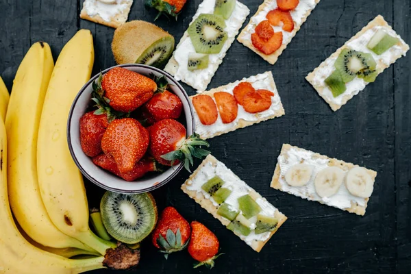 Krekry se sýrem a ovoce: banány, jahodami a kiwi — Stock fotografie
