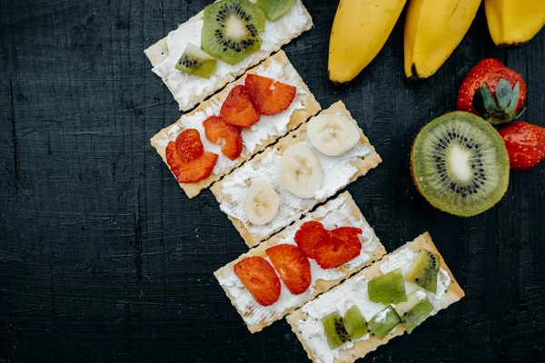 Galletas con queso y frutas: plátanos, fresas y kiwi — Foto de Stock