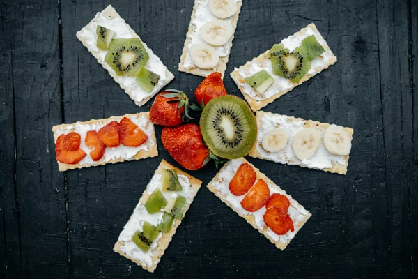 Close up of a variety of crackers with cheese and fruits: banana — Stock Photo, Image