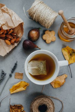 Sıcak çay, badem, tanımlama bilgileri, tatlım, incir, kuru yapraklar üzerinde lavanta 