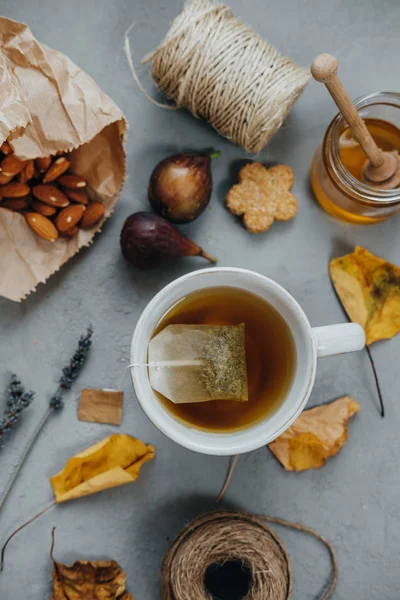 Sıcak çay, badem, tanımlama bilgileri, tatlım, incir, kuru yapraklar üzerinde lavanta 