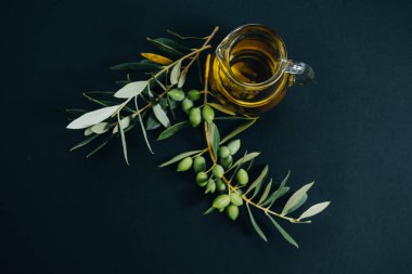 Üstten Görünüm zeytinyağı ve siyah arka plan üzerine yeşil şube