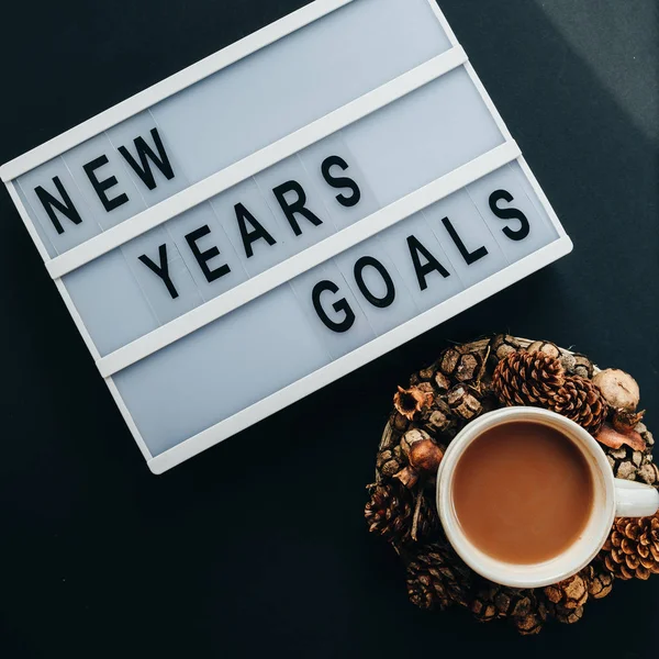 "GOALS" text on desk and cup of cocoa on black background, top v — Stock Photo, Image