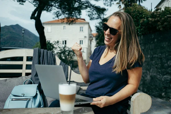Mujer exitosa y feliz en gafas de sol trabajando con el ordenador portátil en — Foto de Stock