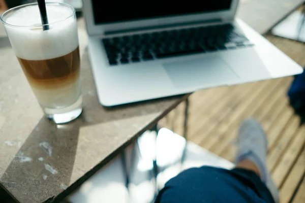 Κάτοψη του καφέ latte, το laptop σε εξωτερική καφετέρια το καλοκαίρι — Φωτογραφία Αρχείου