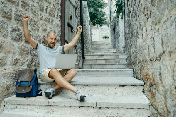 Serbest meslek sahibi adam bir dizüstü bilgisayar üzerinde çalışan onun ellerini kaldırdı 
