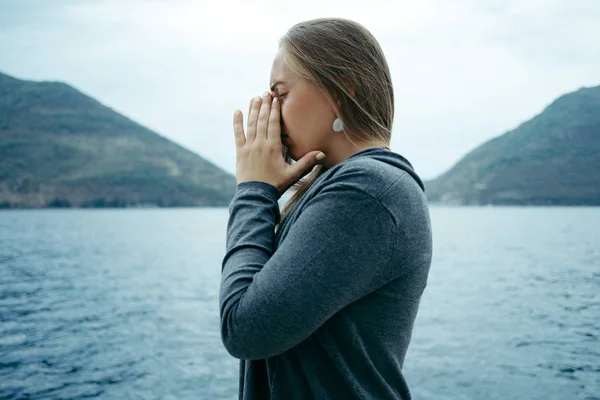 Giovane triste donna piangendo vicino al mare con l'orizzonte nel bac — Foto Stock