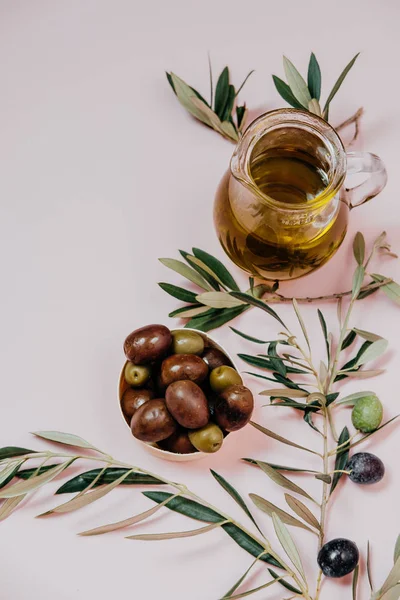 Taze koyu ve yeşil zeytin, petrol ve pembe bir arka plan yapraklarda, — Stok fotoğraf