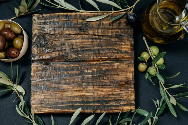 Snack saludable: aceitunas oscuras y verdes, aceite, queso de cabra en una madera —  Fotos de Stock