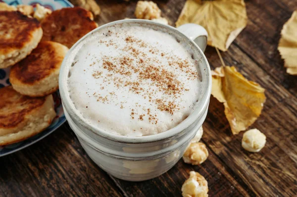 Heißer Cappuccino mit Popcorn, Apfel, Kuchen, Blättern auf dem alten Woo — Stockfoto