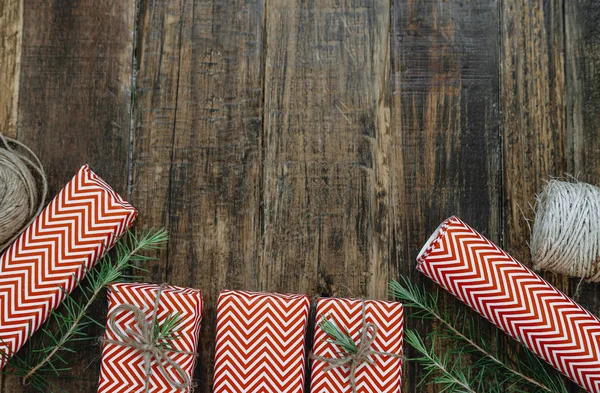 Ovanifrån julklapp röda lådor, packning, garn, spruce gren — Stockfoto
