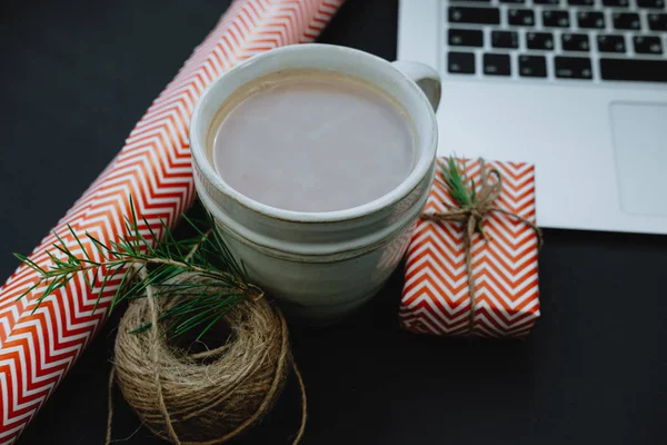 Closeup tasse de cacao avec ordinateur portable, cadeaux décoratifs rouges et spruc — Photo