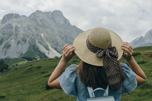 Bir kadın yolcunun şapka tutan mavi sırt çantası ile dönüp bakmak — Stok fotoğraf