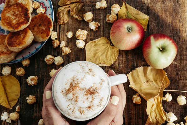 Patlamış mısır, elma, kek, yaprak ile sıcak kakao ile kadının el — Stok fotoğraf