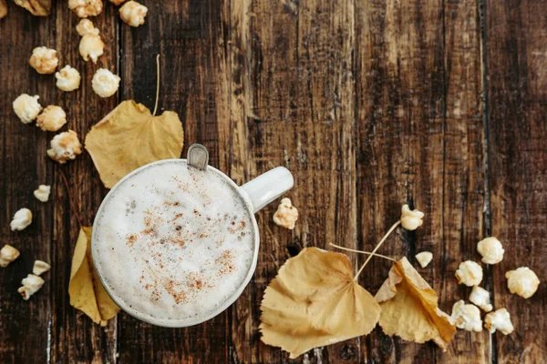 Sıcak kakao (kahve) ile patlamış mısır, üstten görünüm yaprakları eski w — Stok fotoğraf