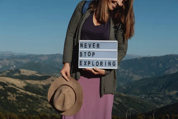 Mujer viajera en sombrero y mochila con placa con texto en ba —  Fotos de Stock