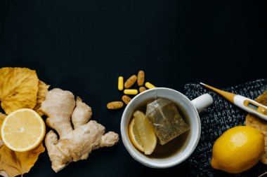 Soğuk ve hasta. Çay limon, termometre, zencefil, eşarp, tablo ile