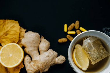 Soğuk ve hasta. Çay limon, termometre, zencefil, eşarp, tablo ile