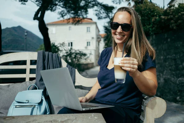 Милая молодая женщина в солнечных очках работает с ноутбуком на открытом воздухе ок — стоковое фото