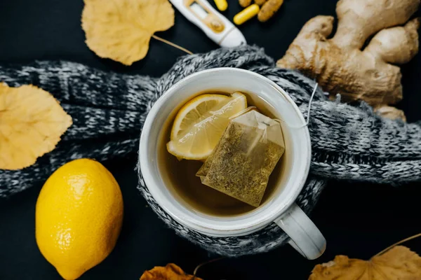 Concepto de enfermedad: Té con limón, termómetro, jengibre, bufanda, lengüeta — Foto de Stock