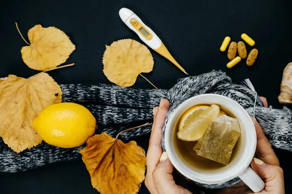 Kadınların elleri ile çay, limon, termometre, zencefil, eşarp, Masa — Stok fotoğraf