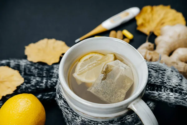 Closeup τσάι με λεμόνι, τζίντζερ, θερμόμετρο, κασκόλ, δισκία και — Φωτογραφία Αρχείου