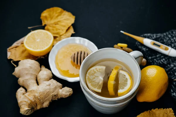 Frío y enfermo. Cariño, té con limón, termómetro, jengibre, bufanda — Foto de Stock