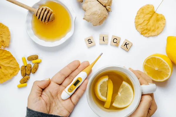 Üstten Görünüm kadın çay ve termometre, ahşap kelime ile hasta eller,