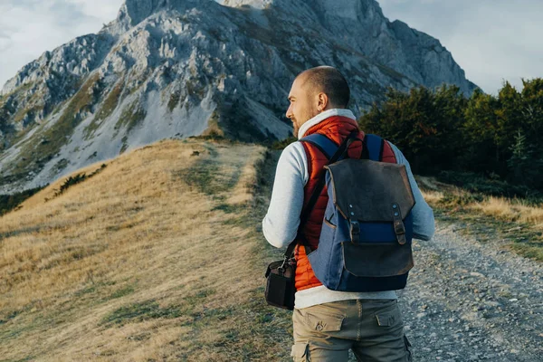 Uomo escursionista con zaino a piedi e guardando la montagna — Foto Stock