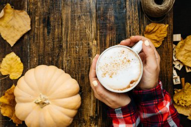 Kadınla rustik ahşap arka plan eller, sütlü balkabağı kahve, p