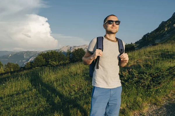 Uzun yürüyüşe çıkan kimse sırt çantası ayakta, dağ arka plan ile 