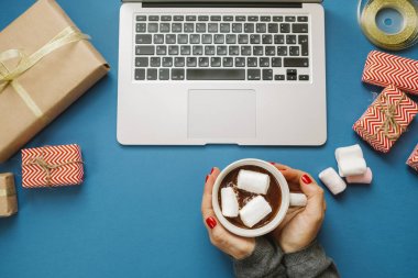 Sıcak kakao marshmallows ve laptop, hediyeler ile kadın elle, 