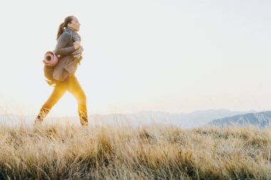 Yol yürüyüş sırt çantası ve yoga mat kadınla Gezgin