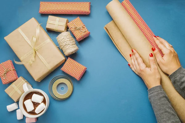 Žena rukou s balicí papír, horké kakao s marshmallows, gi — Stock fotografie