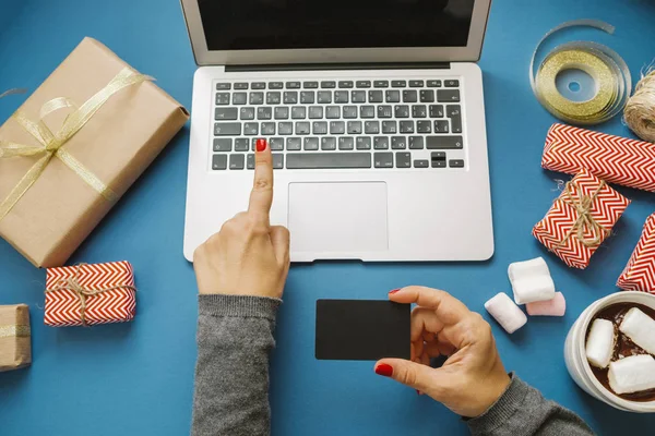 Vrouwelijke handen met credit card en laptop, warme chocolademelk met marshma — Stockfoto