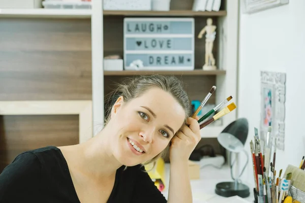 Retrato de artista feliz con pincel en el lugar de trabajo — Foto de Stock