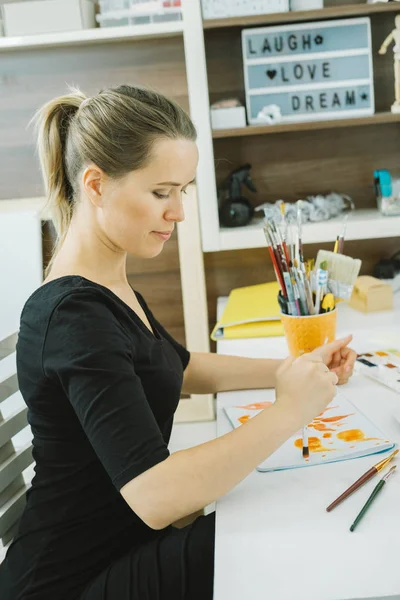 Young woman artist drawing sketch at her workplace in studio — Stock Photo, Image