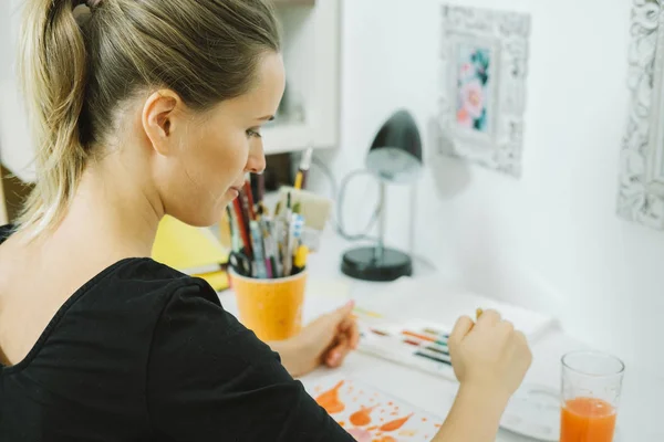 Vista posterior de la artista joven dibujo boceto en su lugar de trabajo — Foto de Stock