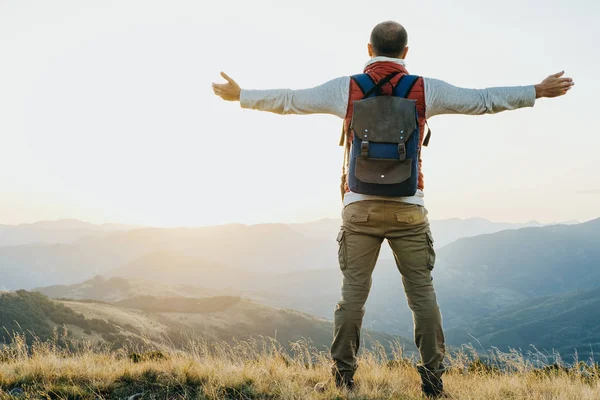 Wandelaar met rugzak permanent en zijn handen op de berg ba rasing — Stockfoto